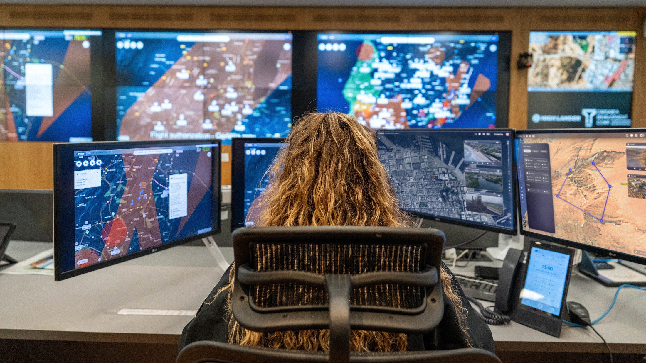 An operator monitoring live airspace maps across several screens